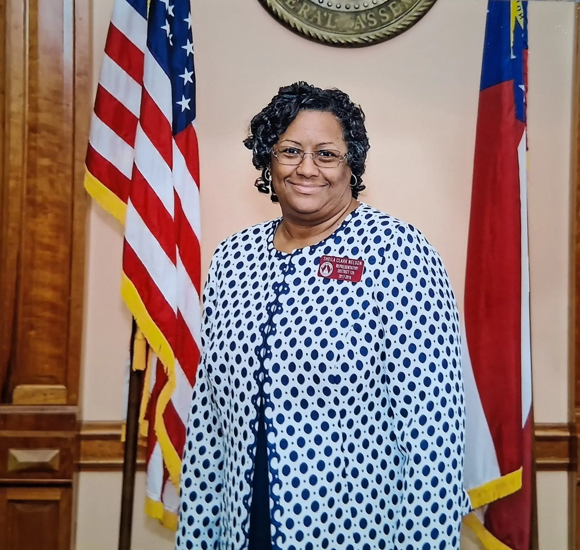 Sheila Nelson standing in between the US and Georgia State flags